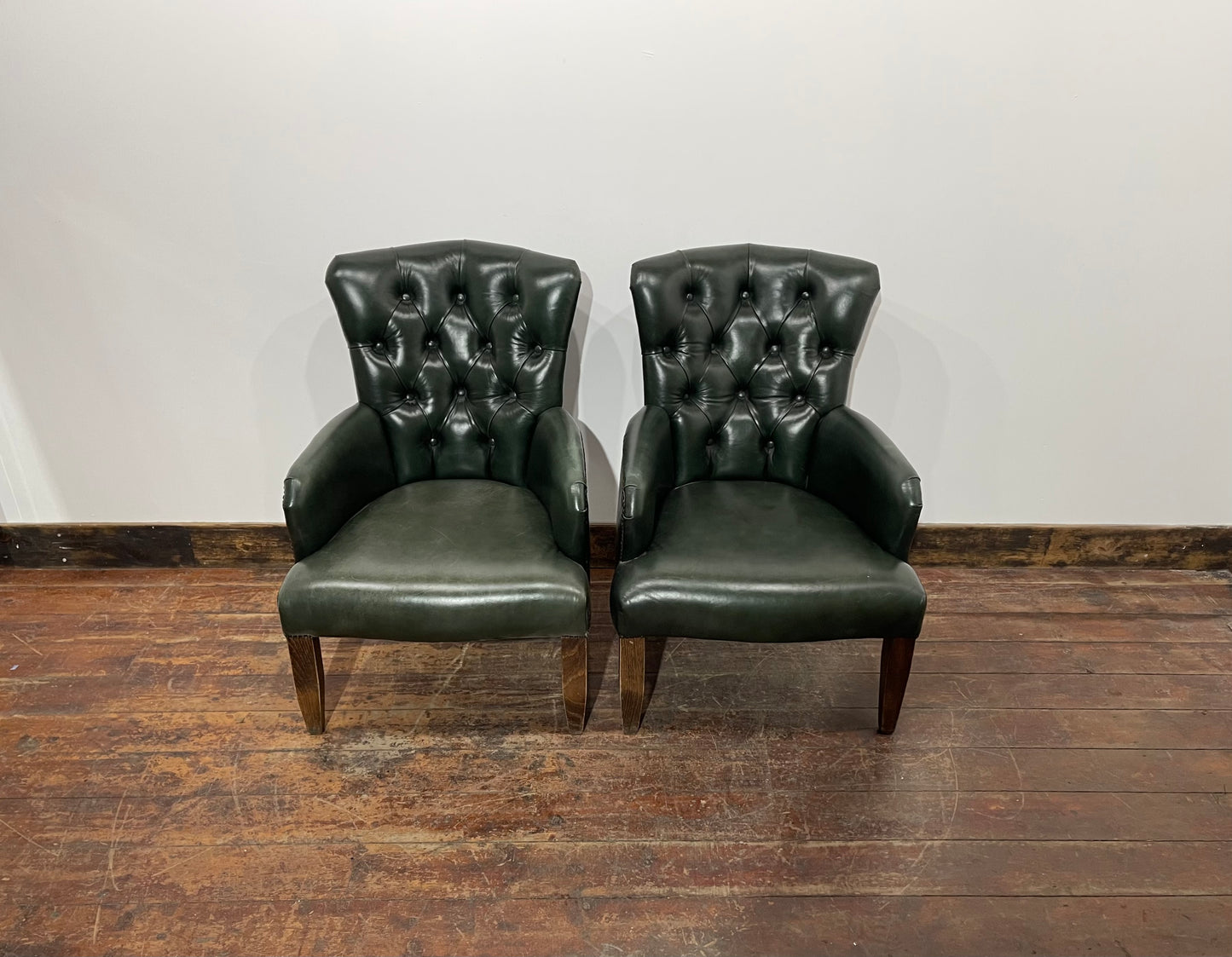 Pair of green leather armchairs with button backs