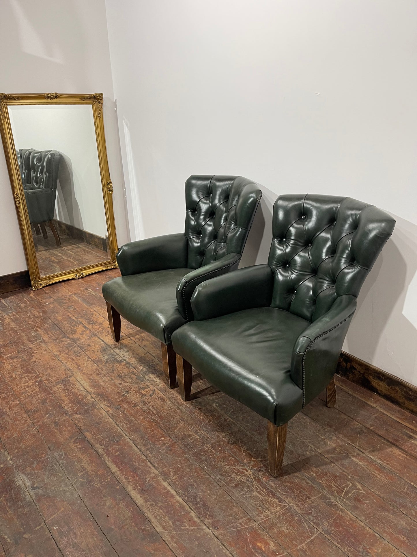 Pair of green leather armchairs with button backs