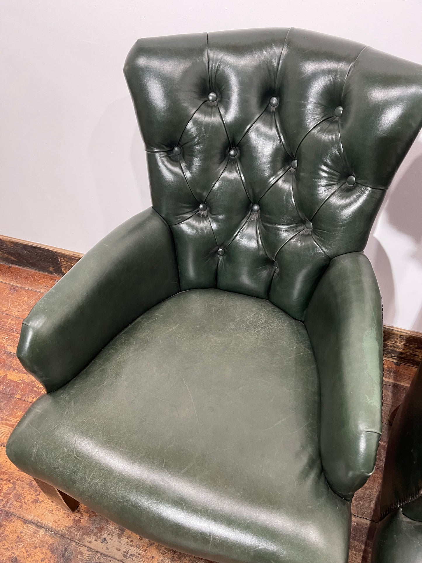 Pair of green leather armchairs with button backs