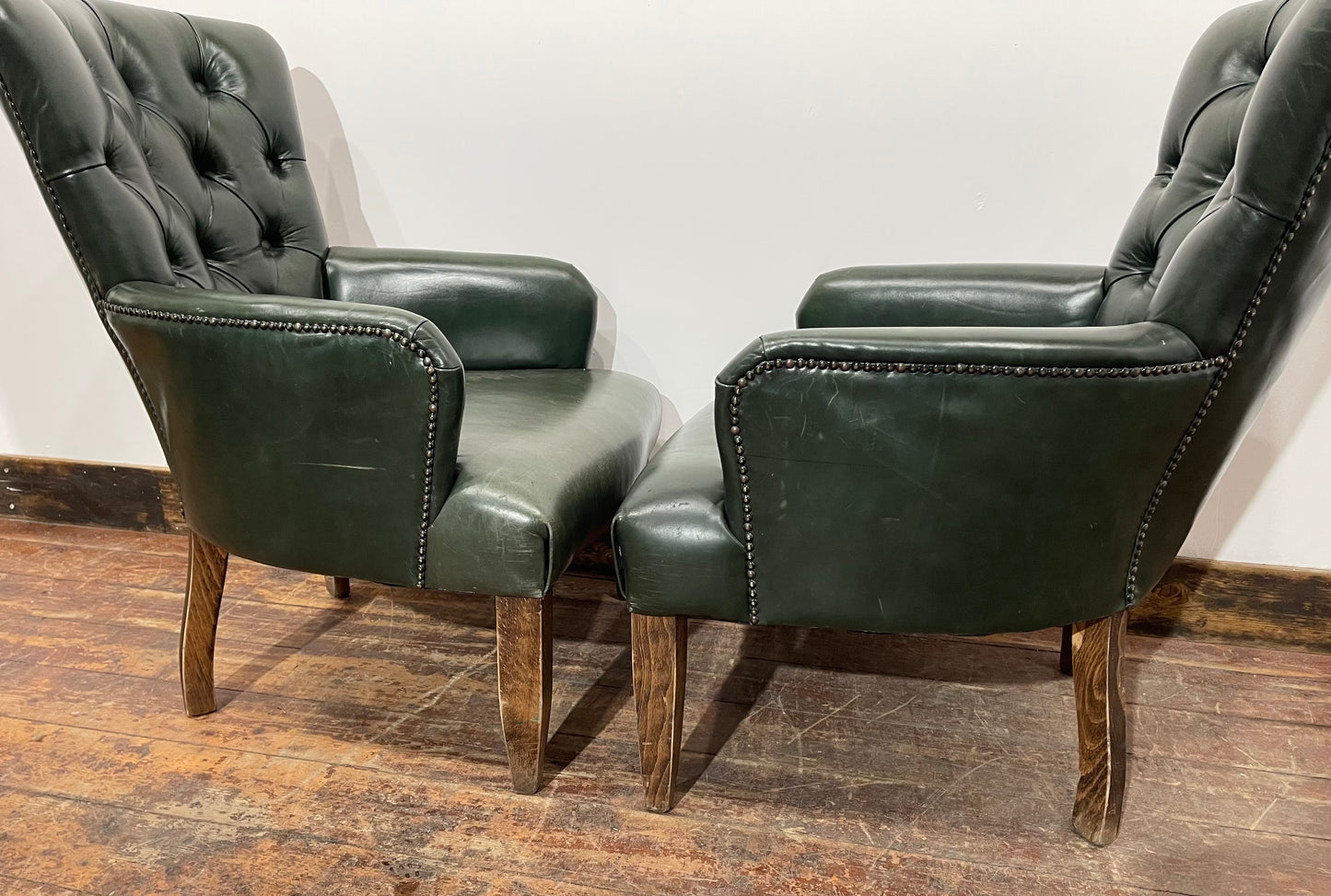 Pair of green leather armchairs with button backs