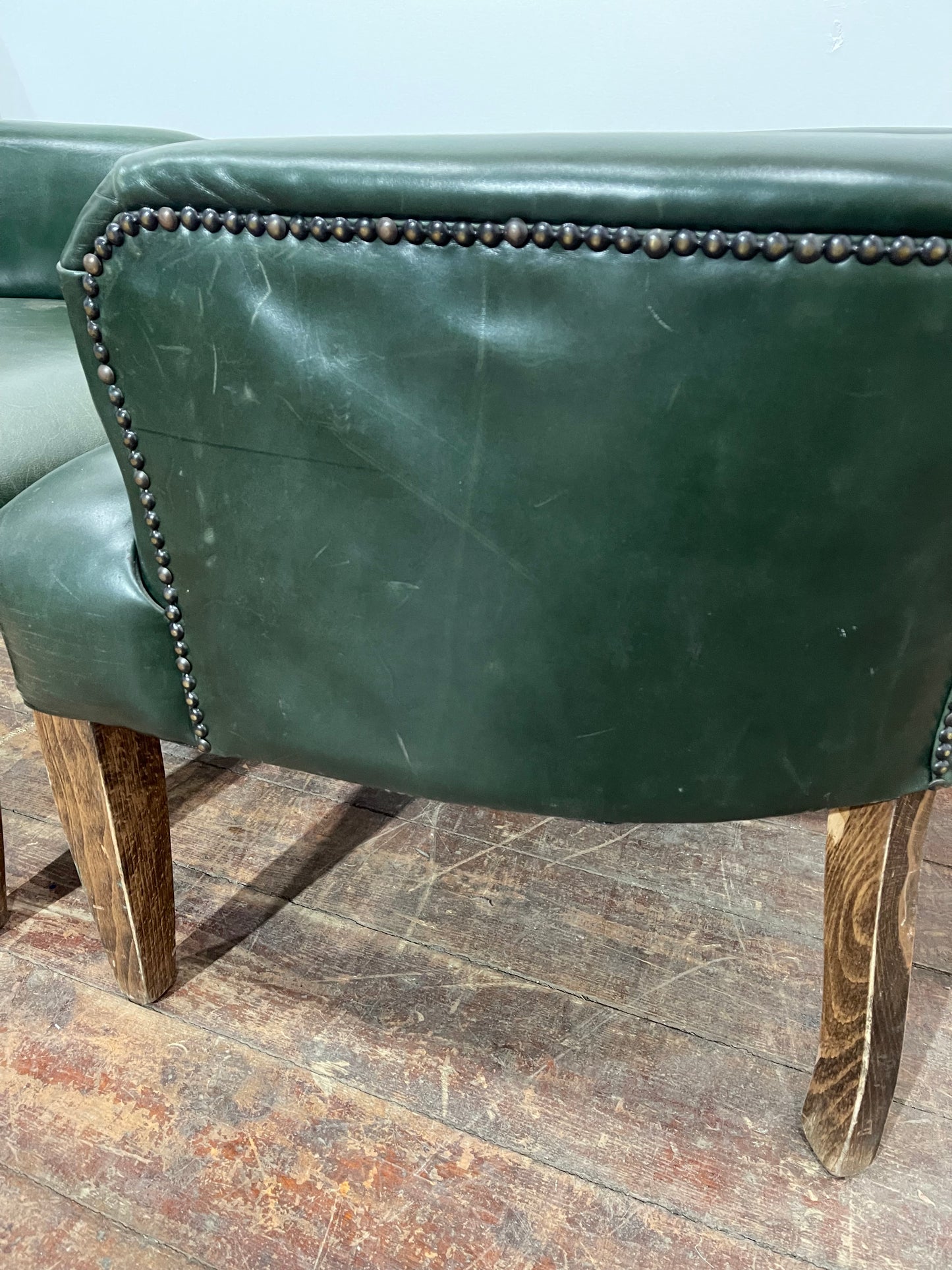 Pair of green leather armchairs with button backs