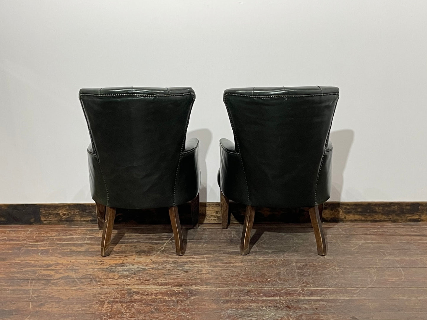 Pair of green leather armchairs with button backs