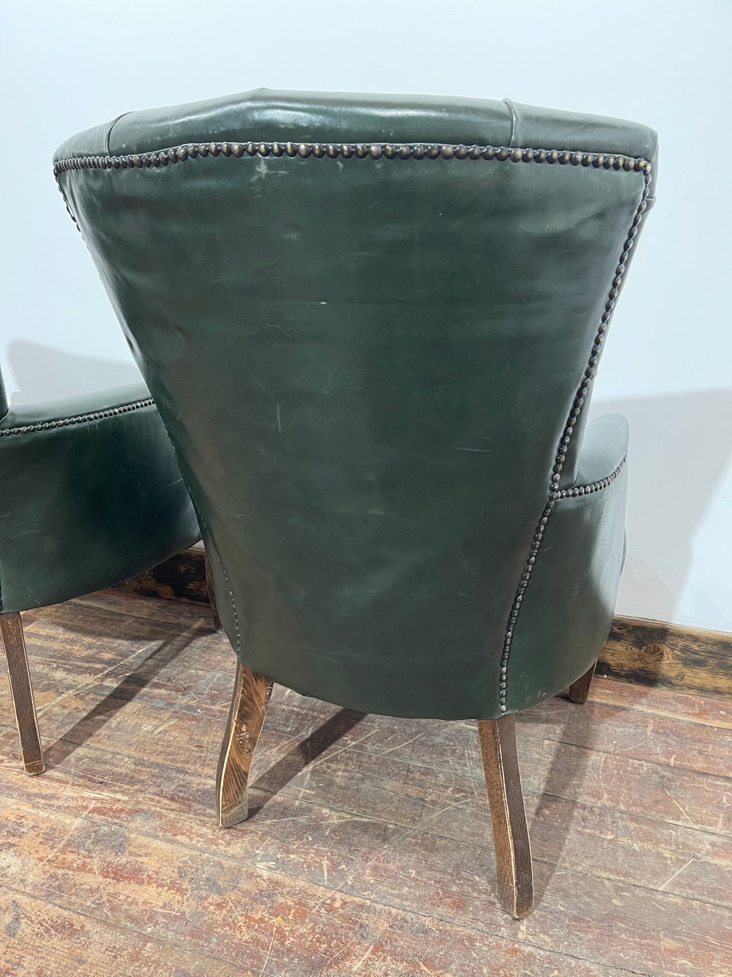 Pair of green leather armchairs with button backs