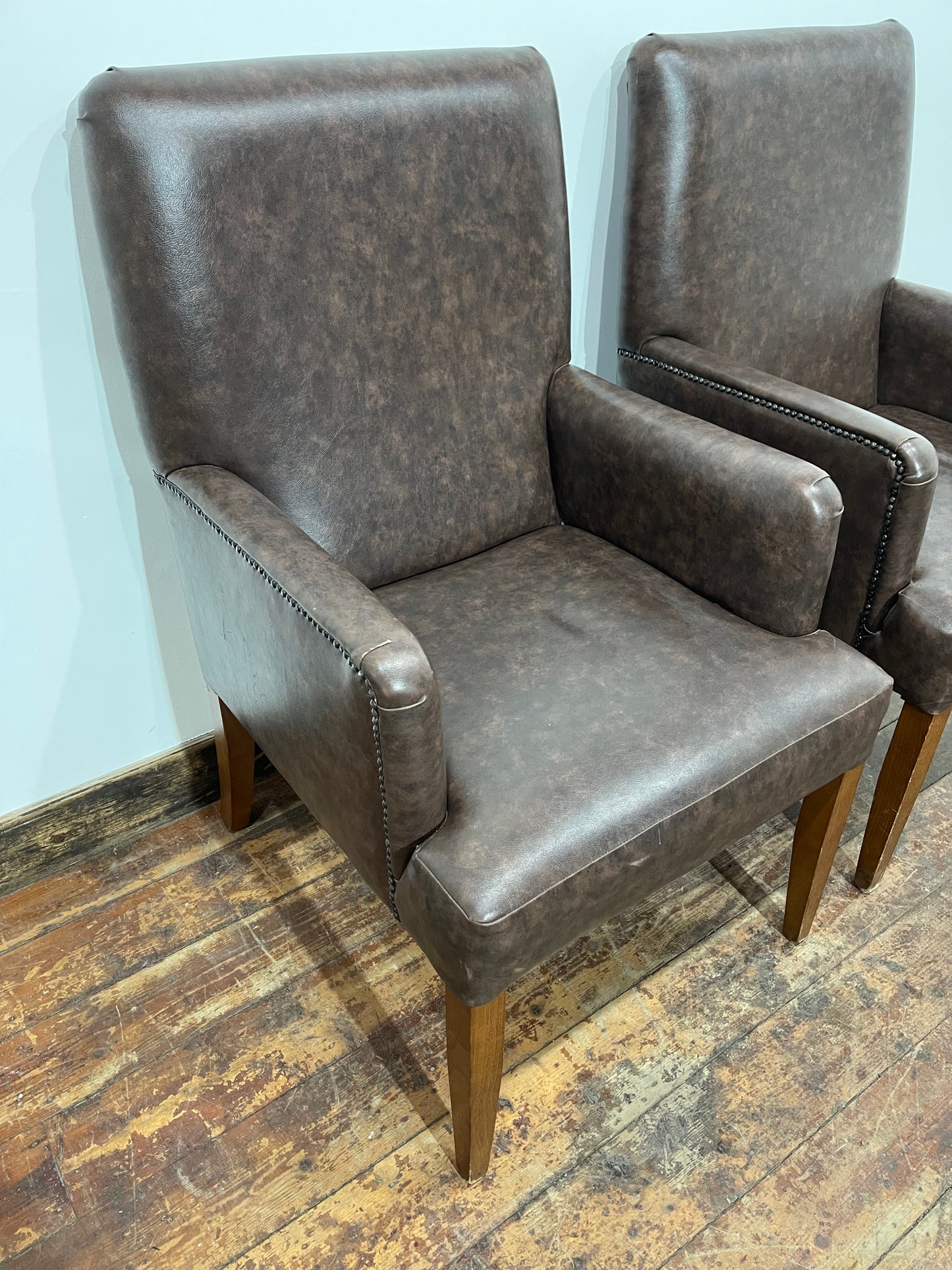 Matching pair of brown faux-leather armchairs