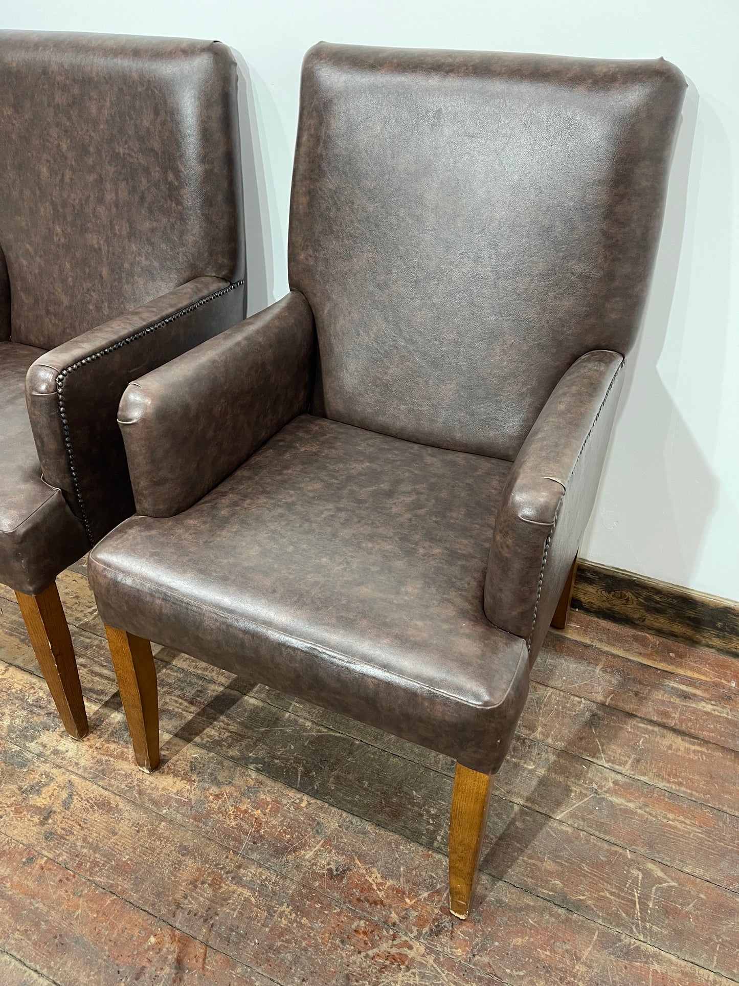 Matching pair of brown faux-leather armchairs