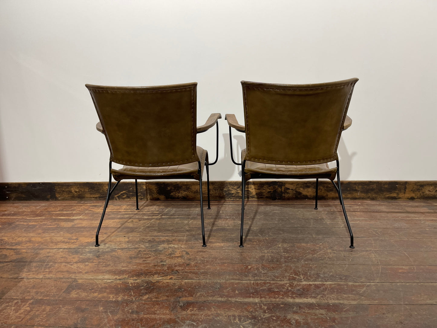 Pair of tan leather armchairs with metal frame