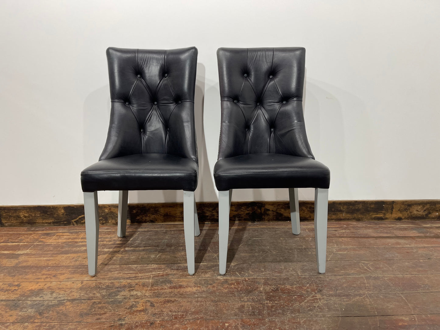 Pair of high back black studded chairs