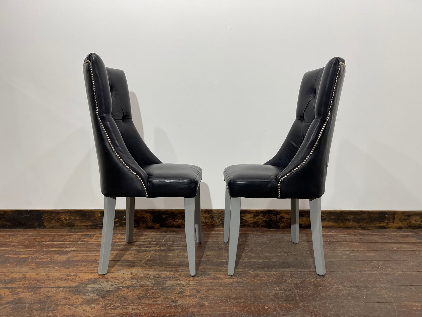 Pair of high back black studded chairs