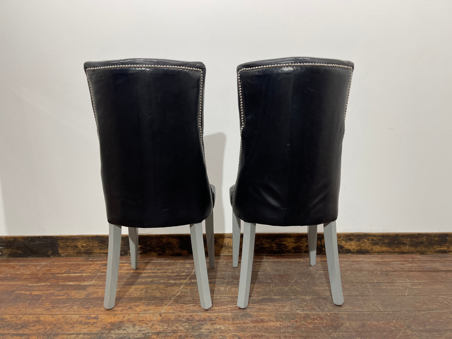 Pair of high back black studded chairs