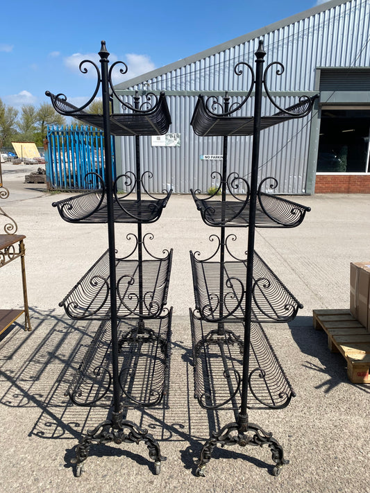 Pair of black metal shelving racks on wheels