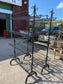 Pair of black metal shelving racks on wheels