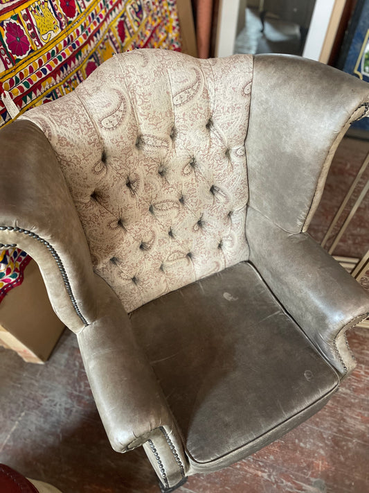 Grey wingback armchair with patterned fabric backrest