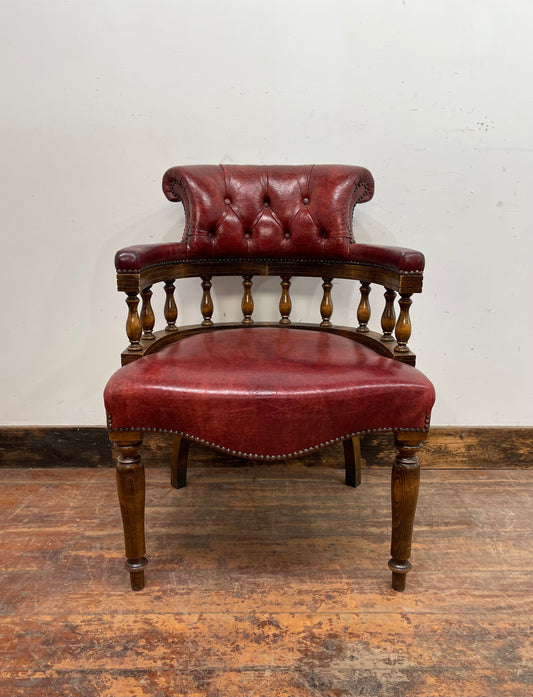 Stunning red leather captain's chair with wooden spindle back