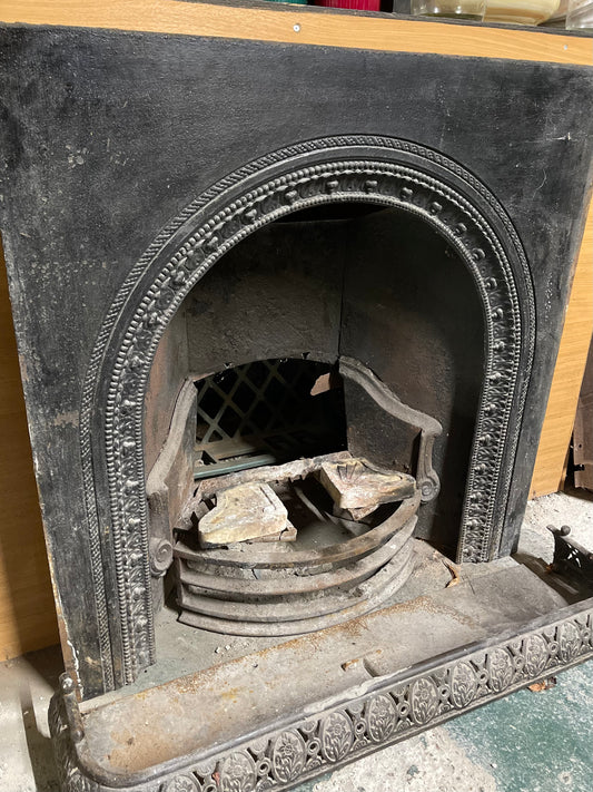 Old cast iron fireplace with decorative fender
