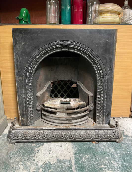 Old cast iron fireplace with decorative fender