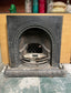 Old cast iron fireplace with decorative fender