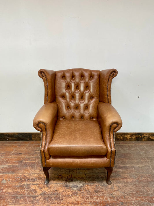Tan leather wingback chair with patterned back