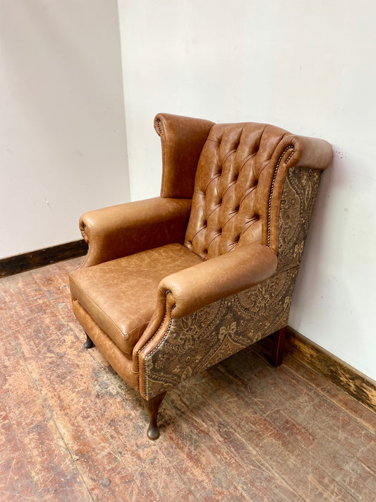Tan leather wingback chair with patterned back