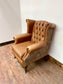 Tan leather wingback chair with patterned back