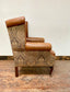 Tan leather wingback chair with patterned back
