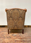 Tan leather wingback chair with patterned back