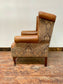 Tan leather wingback chair with patterned back