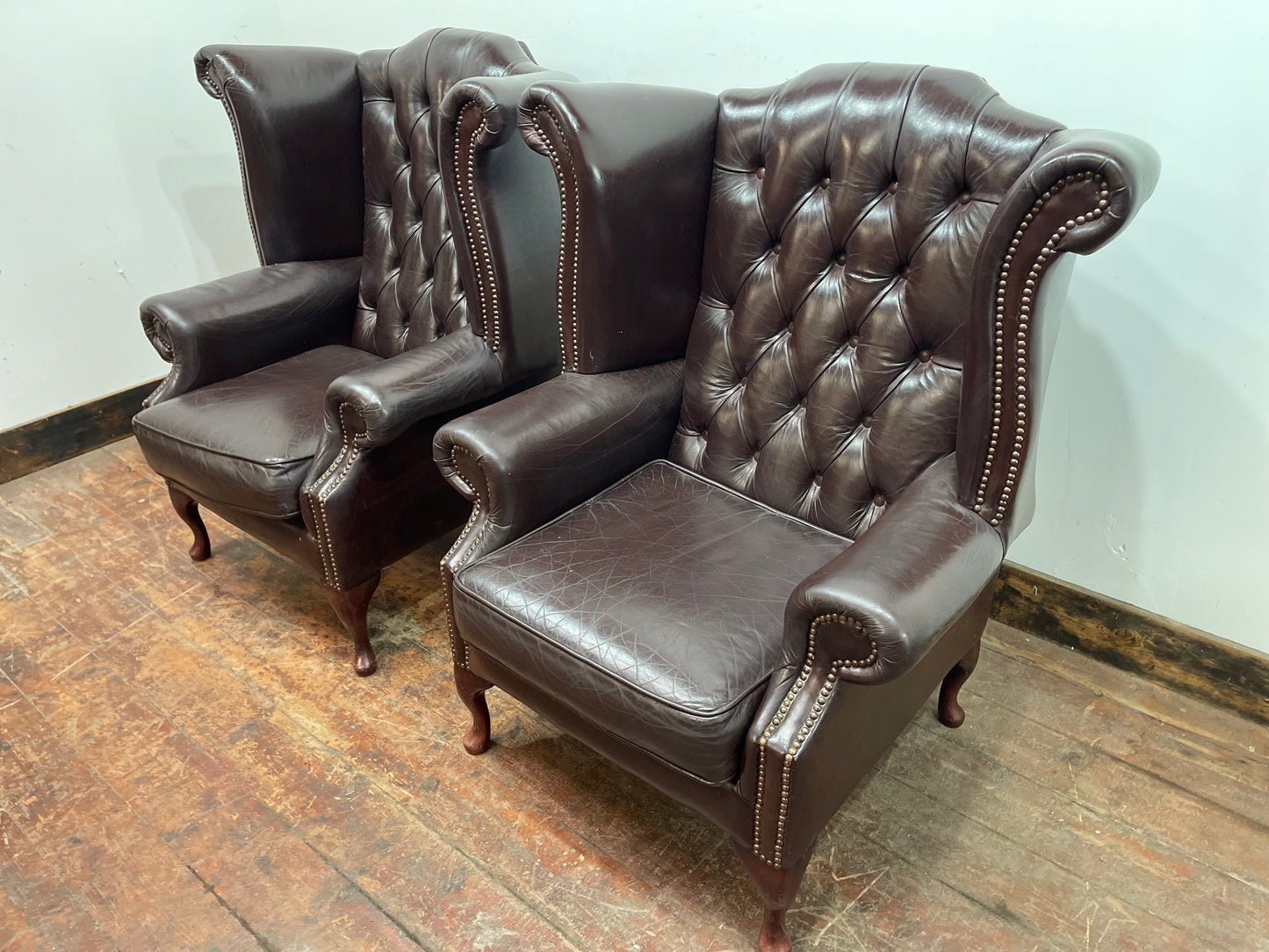 Stunning matching pair of brown leather wingback armchairs