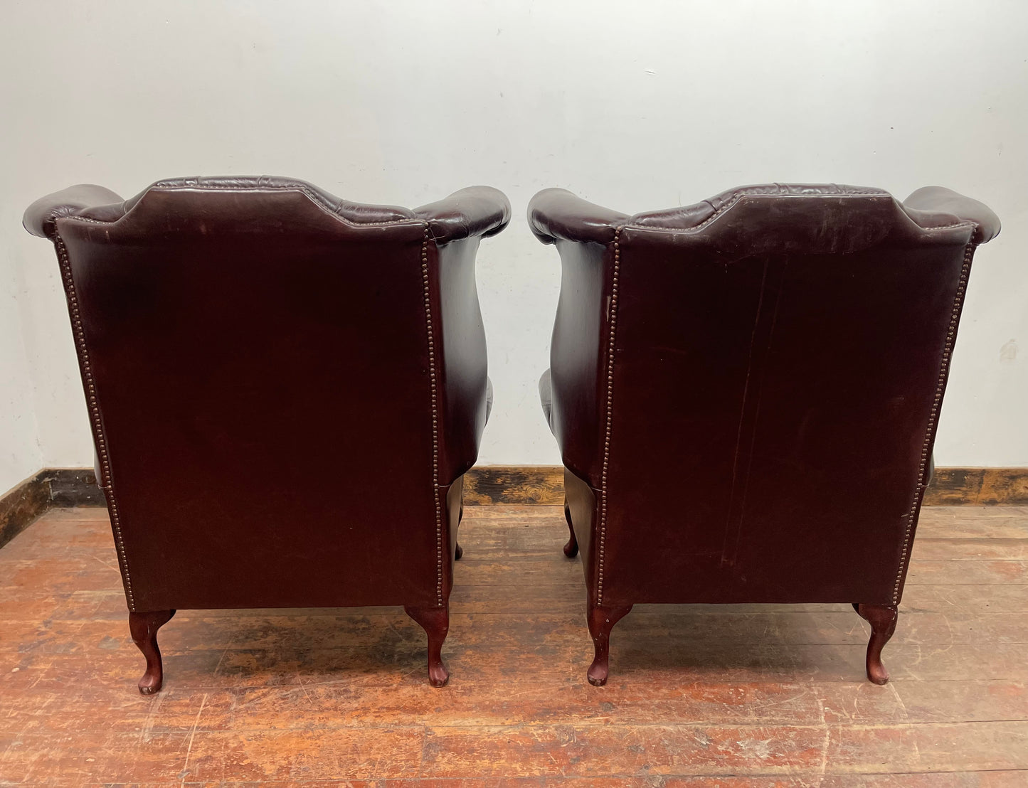 Stunning matching pair of brown leather wingback armchairs