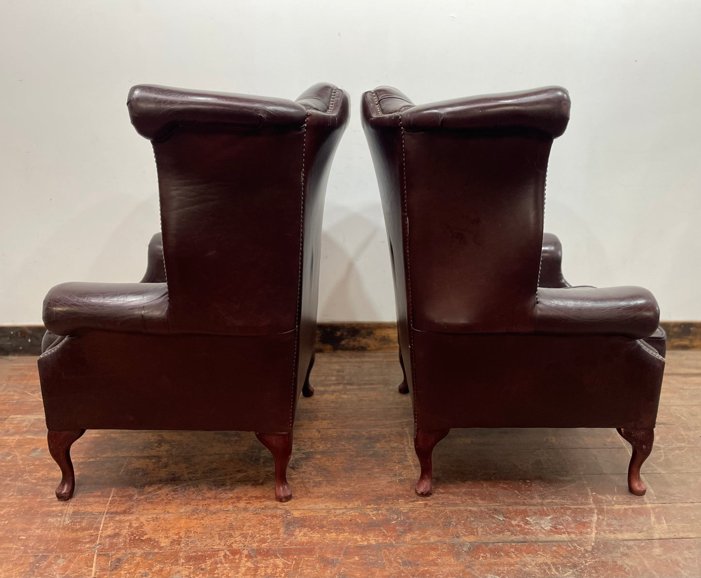 Stunning matching pair of brown leather wingback armchairs