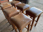 Matching set of 6 tan leather bar stools with square tops