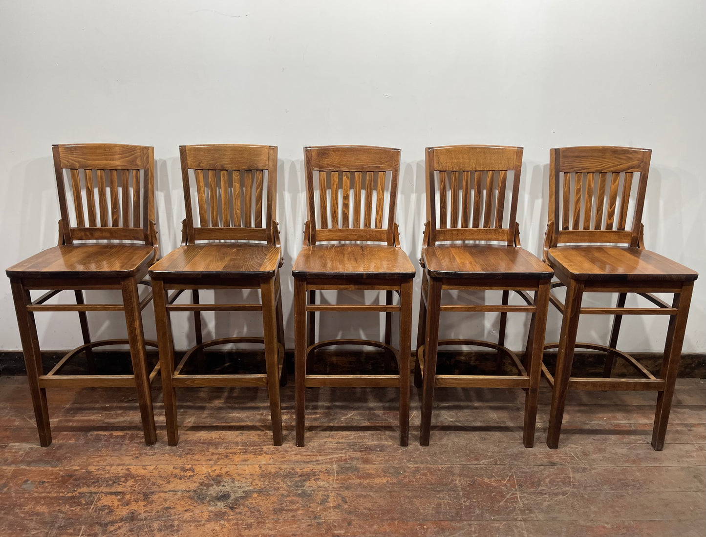 Set of five wooden pub bar stools with backrests