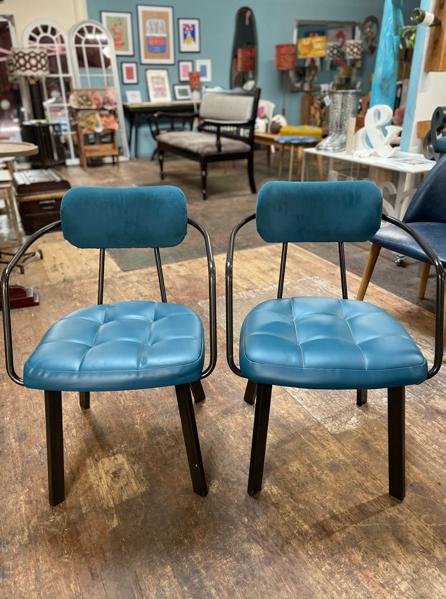 Pair of blue faux-leather chairs and black round table