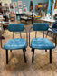Pair of blue faux-leather chairs and black round table