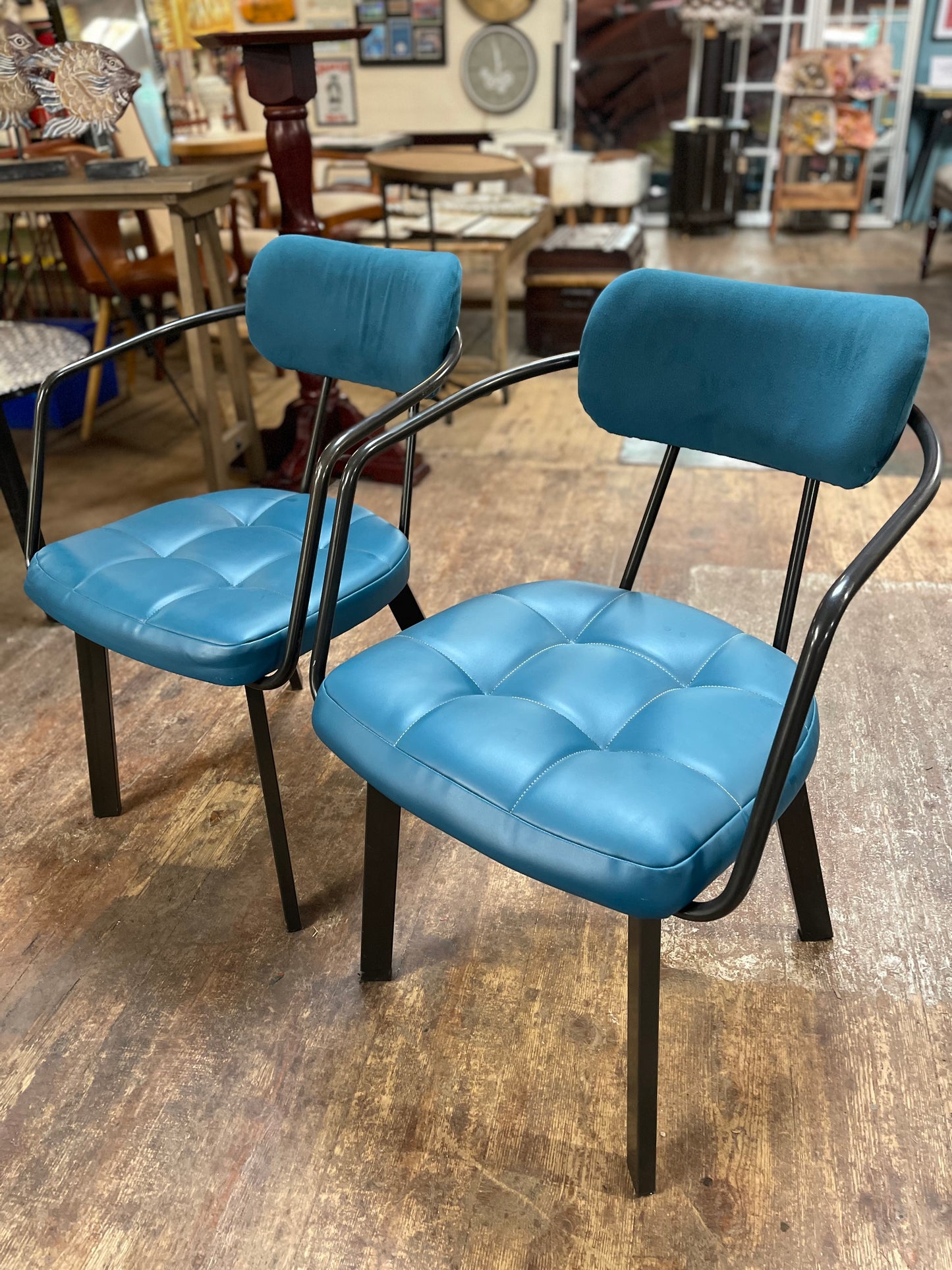 Pair of blue faux-leather chairs and black round table