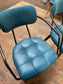 Pair of blue faux-leather chairs and black round table