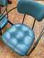Pair of blue faux-leather chairs and black round table