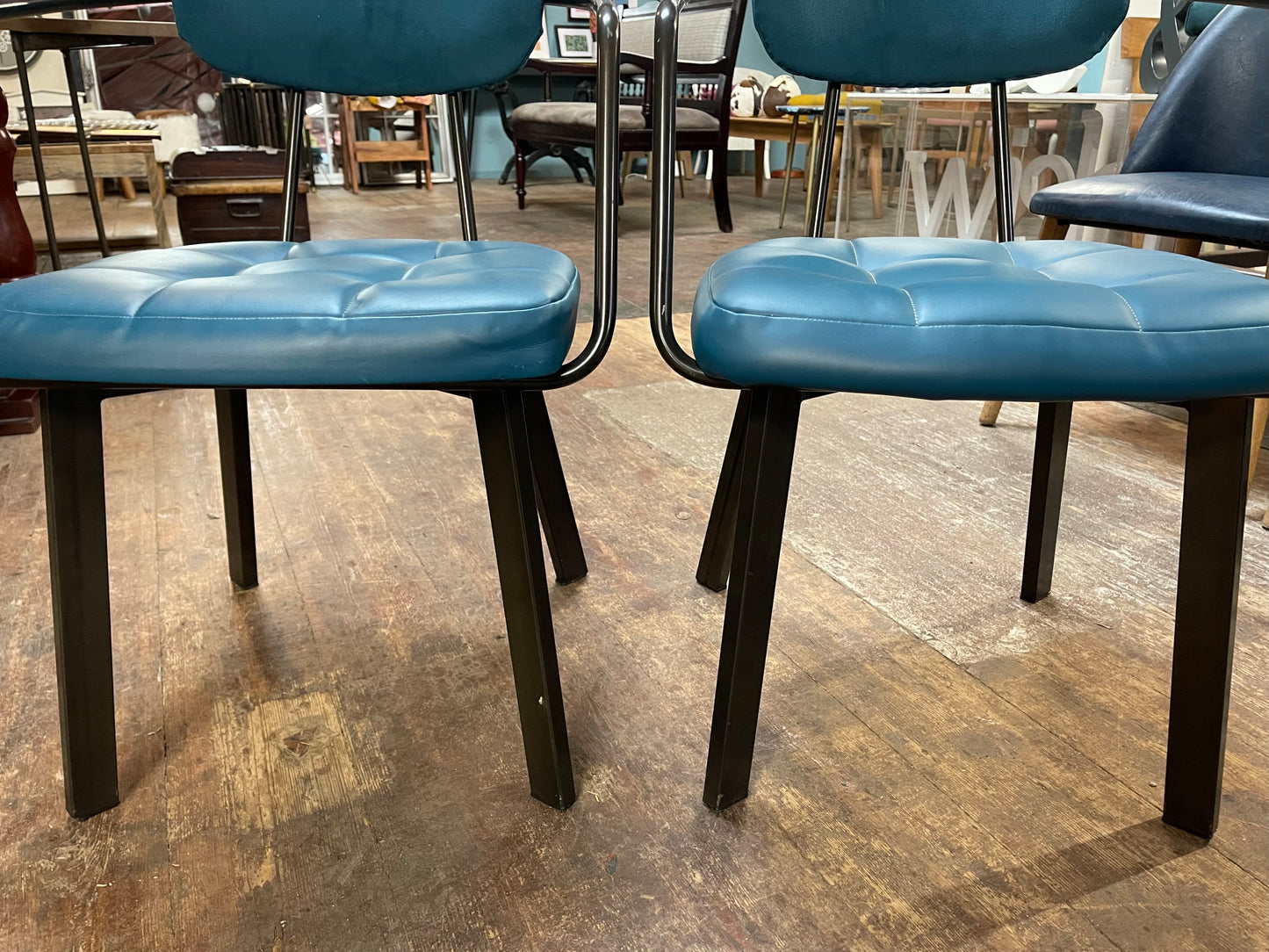 Pair of blue faux-leather chairs and black round table