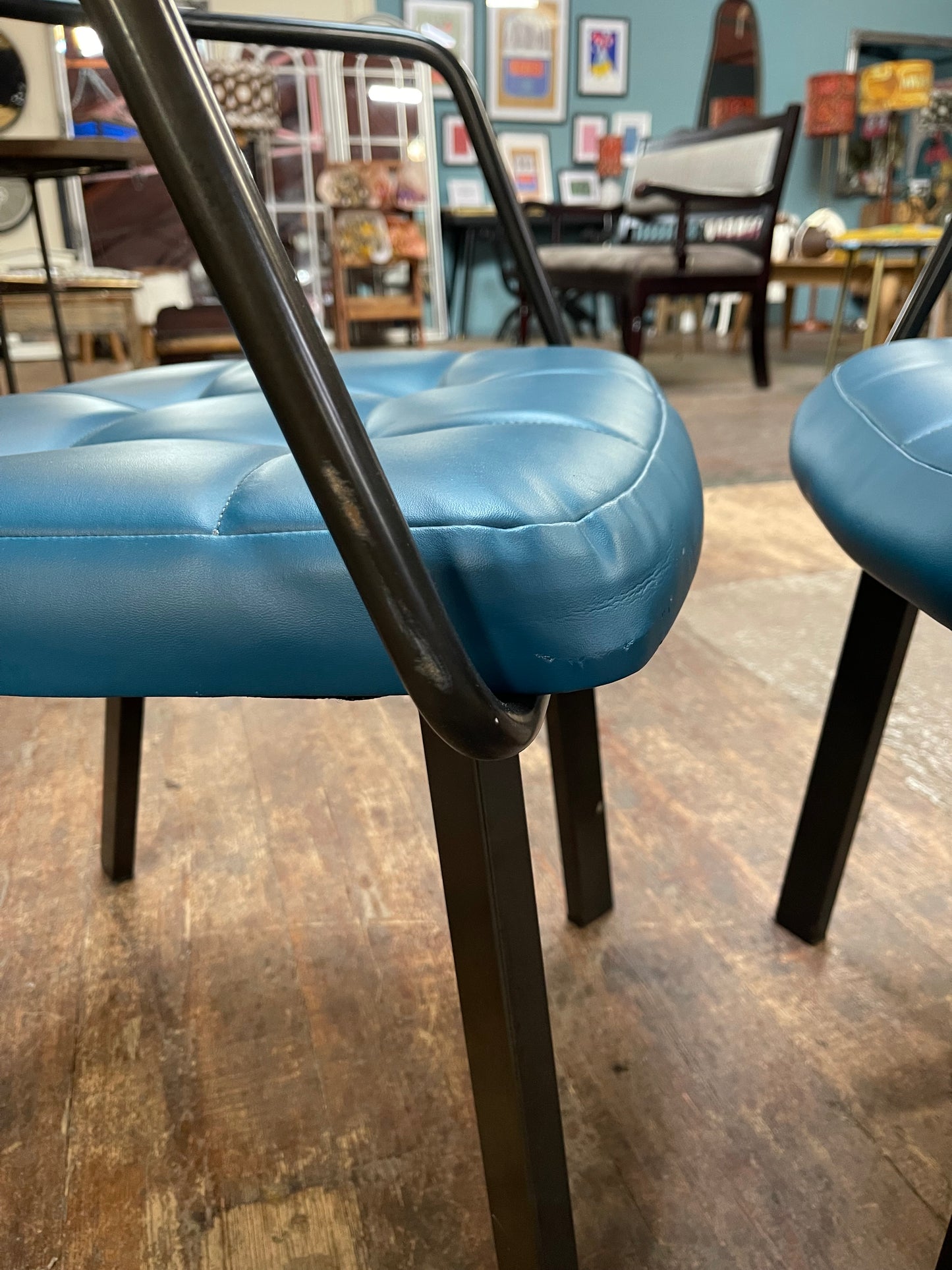 Pair of blue faux-leather chairs and black round table