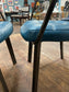 Pair of blue faux-leather chairs and black round table