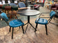 Pair of blue faux-leather chairs and black round table