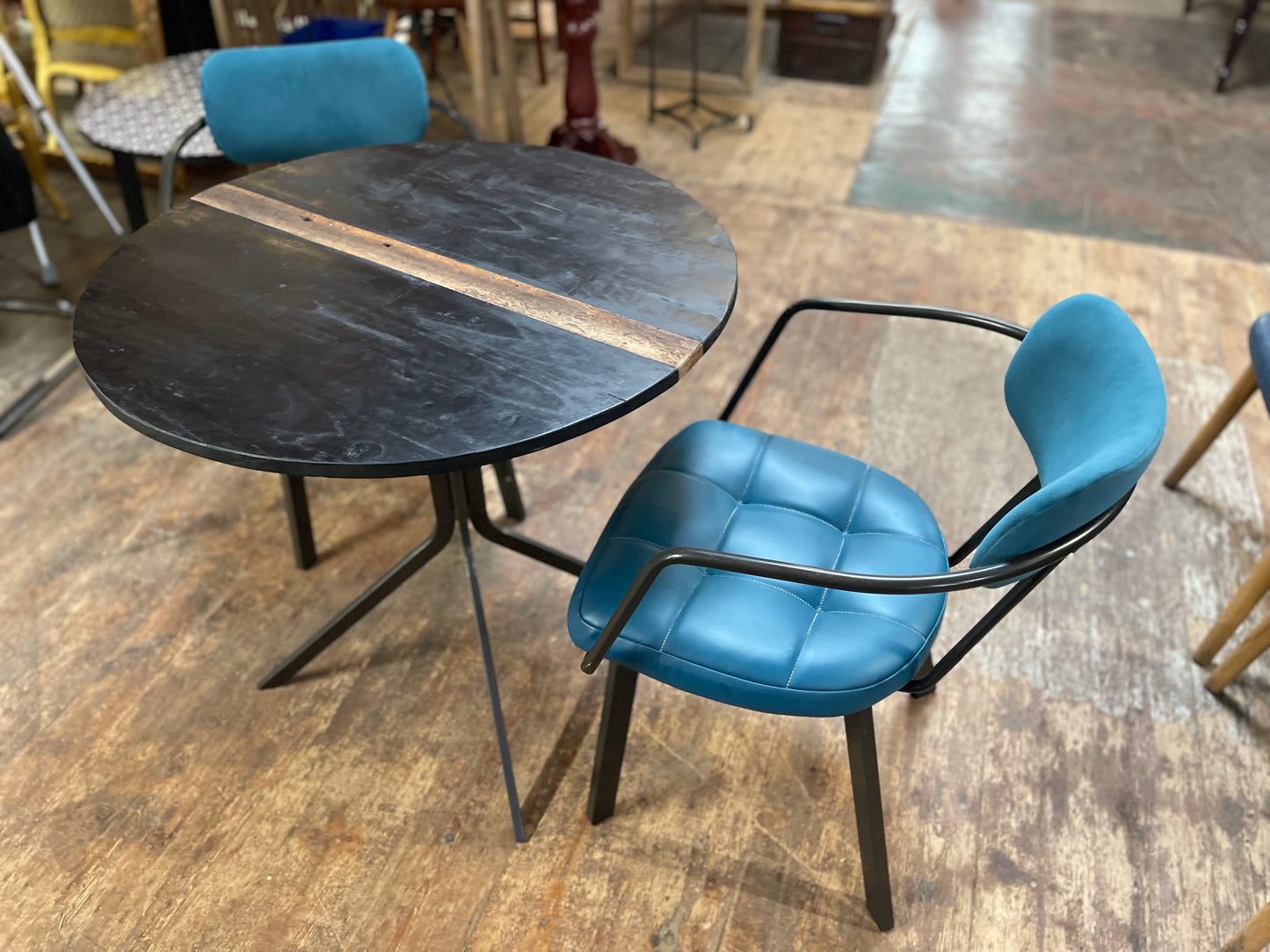 Pair of blue faux-leather chairs and black round table