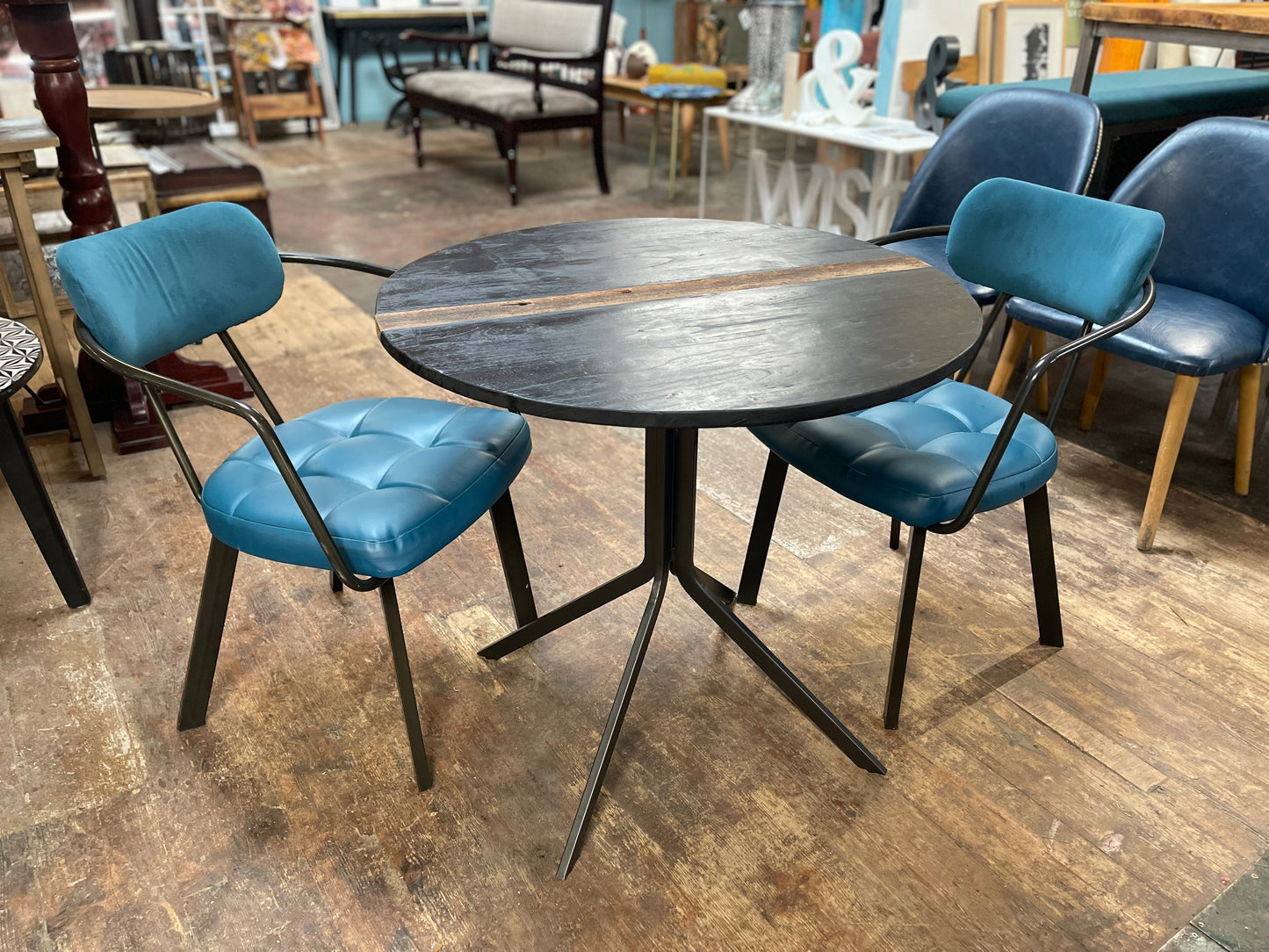 Pair of blue faux-leather chairs and black round table