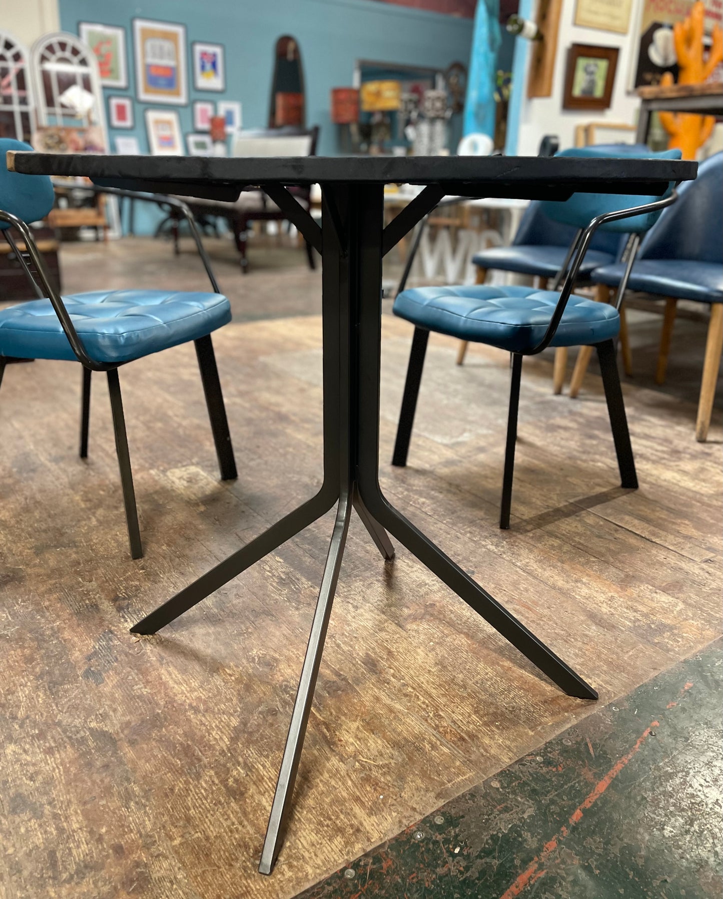 Pair of blue faux-leather chairs and black round table
