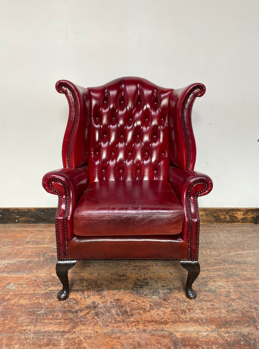 Chesterfield-style red leather wingback armchair