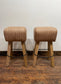 Pair of pommel stools with light tan leather seats