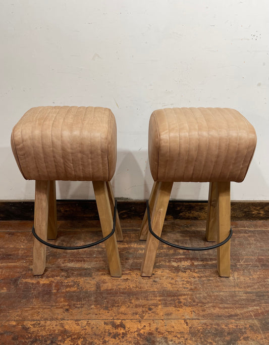 Pair of pommel stools with light tan leather seats