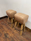 Pair of pommel stools with light tan leather seats