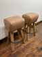 Pair of pommel stools with light tan leather seats