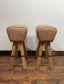 Pair of pommel stools with light tan leather seats