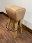 Pommel stool with light tan leather seat